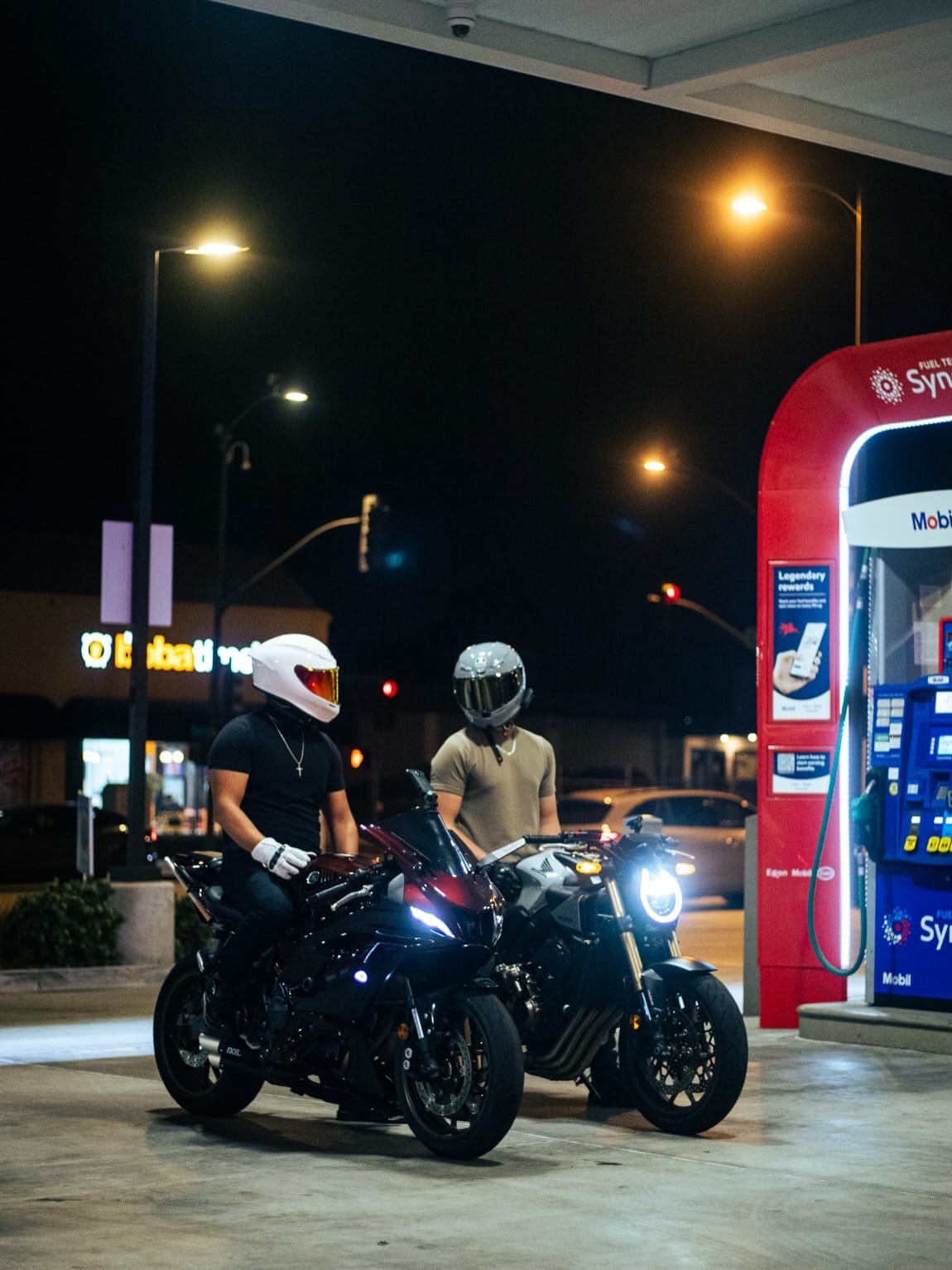 Two riders on their bikes at the pumps